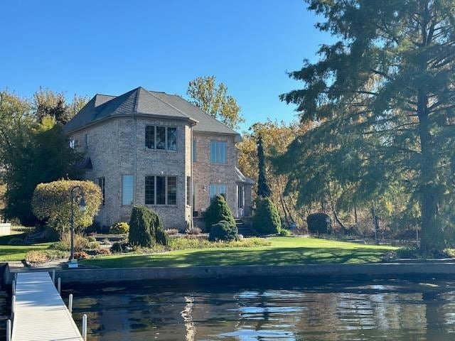 view of property exterior featuring a water view and a lawn