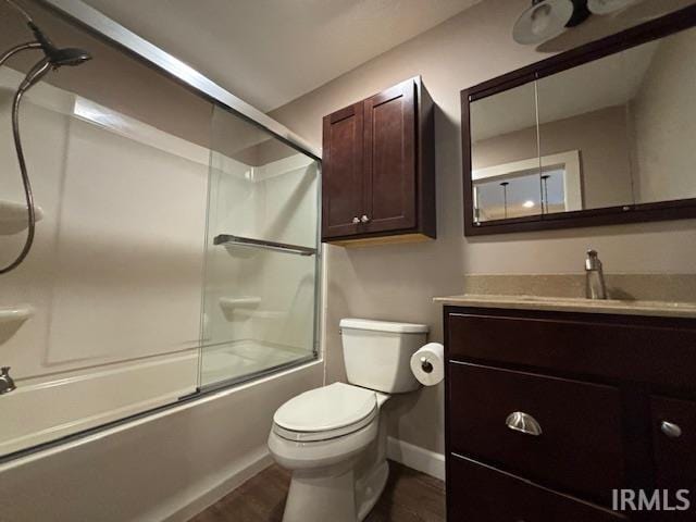 full bathroom featuring bath / shower combo with glass door, wood-type flooring, vanity, and toilet