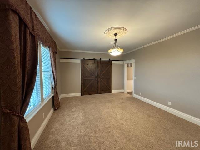 unfurnished bedroom with a barn door, carpet floors, ornamental molding, and multiple windows