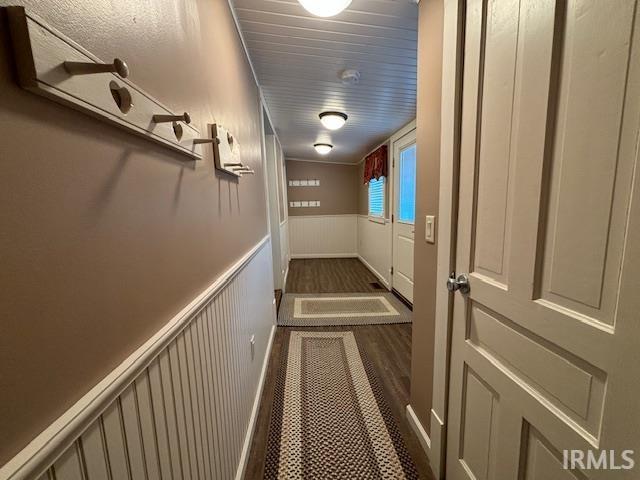 hallway featuring crown molding and dark hardwood / wood-style flooring