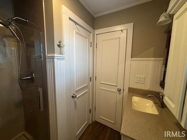 bathroom featuring an enclosed shower, crown molding, hardwood / wood-style flooring, and vanity