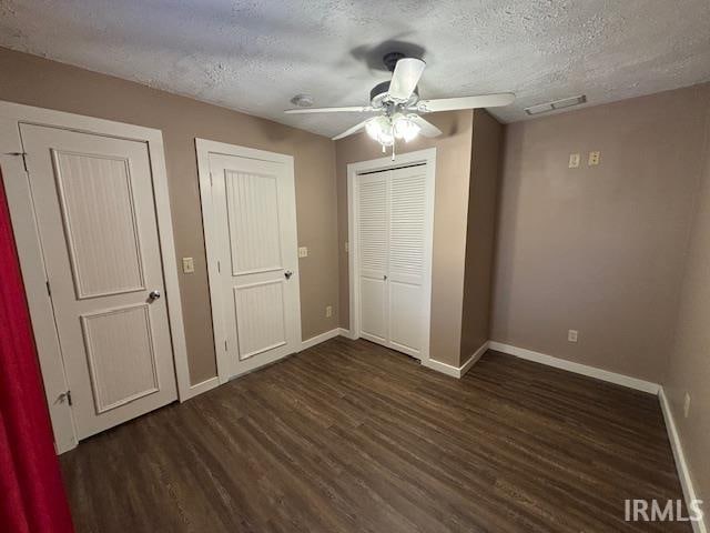 unfurnished bedroom with ceiling fan, dark hardwood / wood-style floors, and a textured ceiling