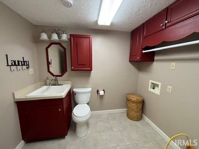 bathroom with vanity, toilet, and a textured ceiling