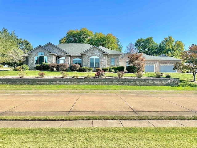 single story home featuring a front lawn and a garage