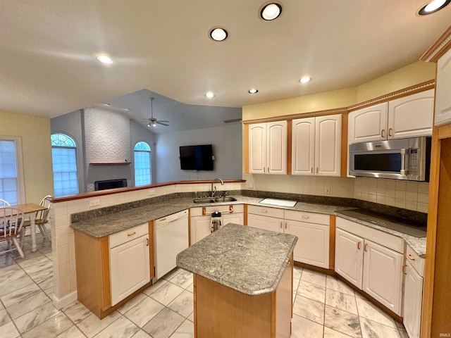 kitchen featuring sink, dishwasher, lofted ceiling, a center island, and black electric stovetop