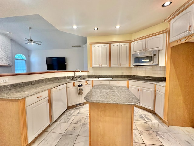 kitchen with black stovetop, a kitchen island, sink, vaulted ceiling, and dishwasher