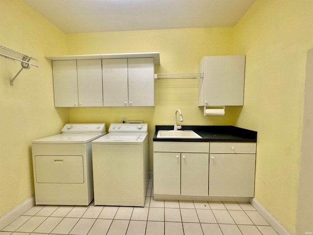 washroom with sink, cabinets, light tile patterned floors, and washer and clothes dryer