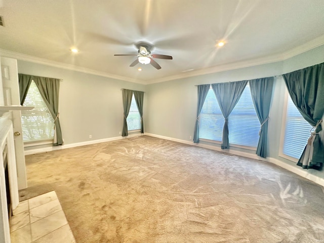 carpeted spare room with crown molding, ceiling fan, and a healthy amount of sunlight