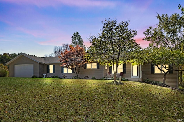 view of front facade with a yard and a garage