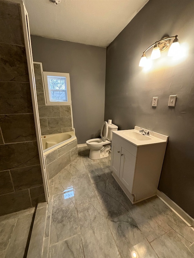 bathroom featuring vanity, toilet, and tiled tub