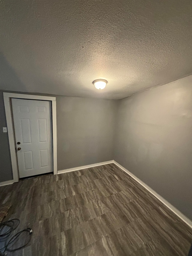 spare room with dark hardwood / wood-style flooring and a textured ceiling