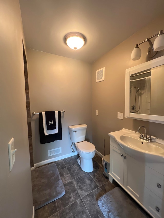 bathroom with vanity, toilet, and tile patterned floors