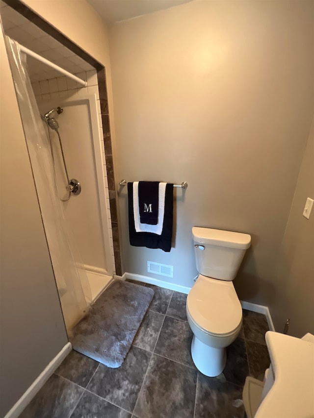 bathroom with tile patterned floors, toilet, and curtained shower