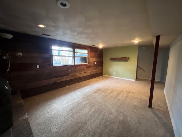 basement featuring wood walls and carpet