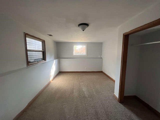 unfurnished bedroom featuring a closet and light colored carpet