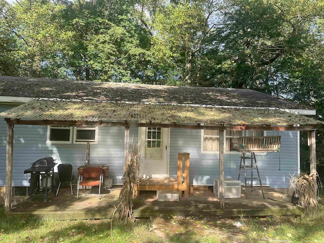 back of property with a wooden deck and a patio