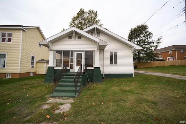 rear view of house with a yard and a sunroom