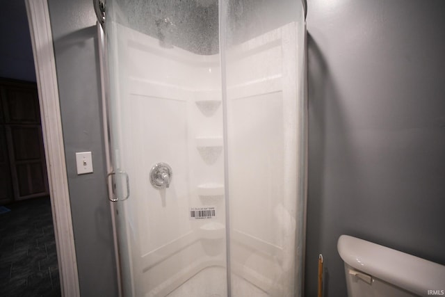 bathroom with an enclosed shower and toilet