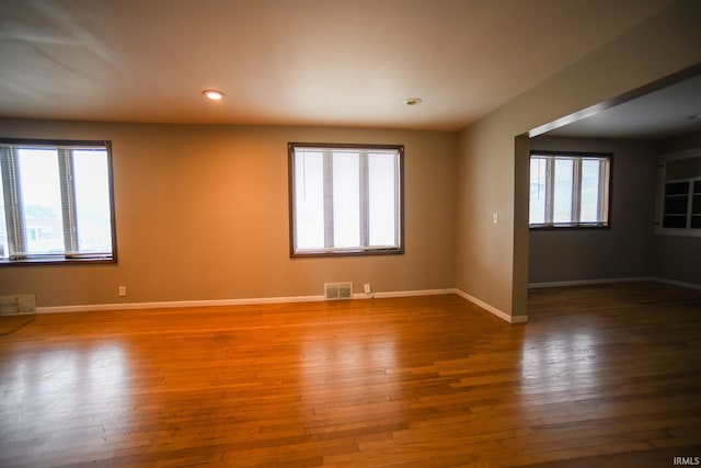 empty room featuring wood-type flooring and plenty of natural light