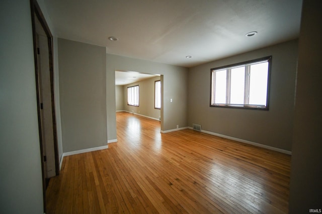 unfurnished room with light wood-type flooring and a healthy amount of sunlight