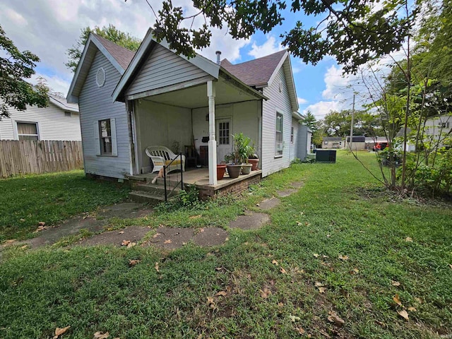 back of house with a patio and a lawn