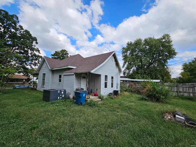 view of side of home featuring a lawn and central AC unit