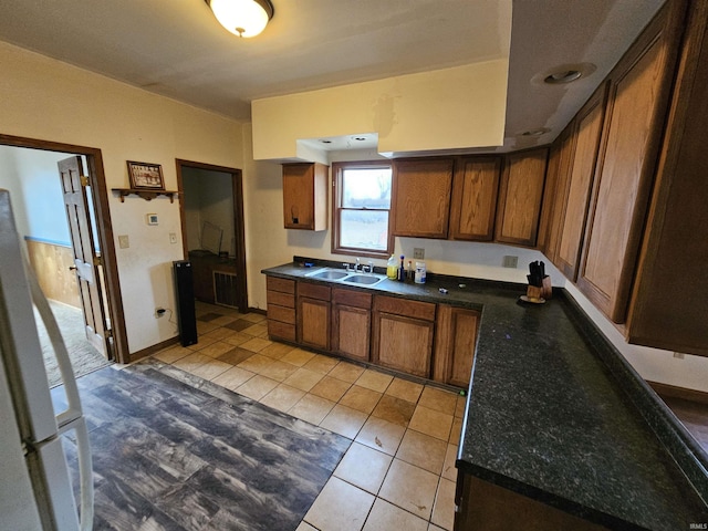 kitchen featuring sink, white refrigerator, radiator heating unit, and light tile patterned floors