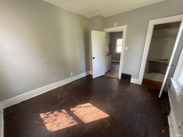 unfurnished bedroom featuring a closet and dark hardwood / wood-style floors