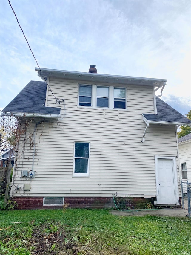 rear view of property featuring a lawn