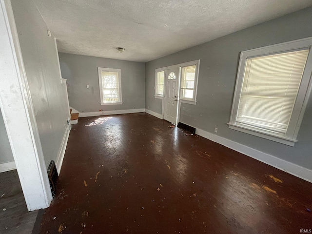 entryway with a textured ceiling and dark hardwood / wood-style floors