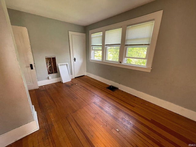 unfurnished room with dark wood-type flooring