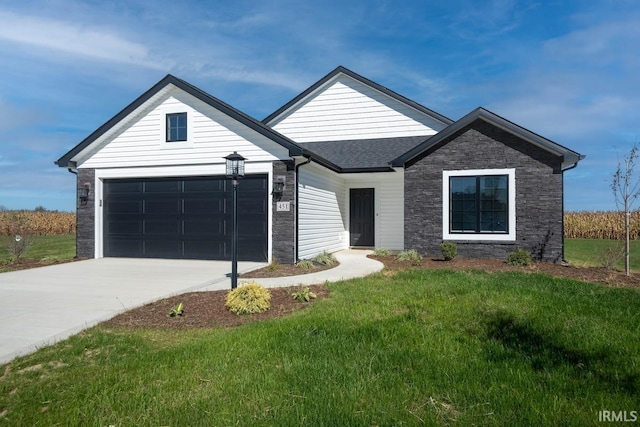 view of front of house with an attached garage, a shingled roof, a front yard, and concrete driveway