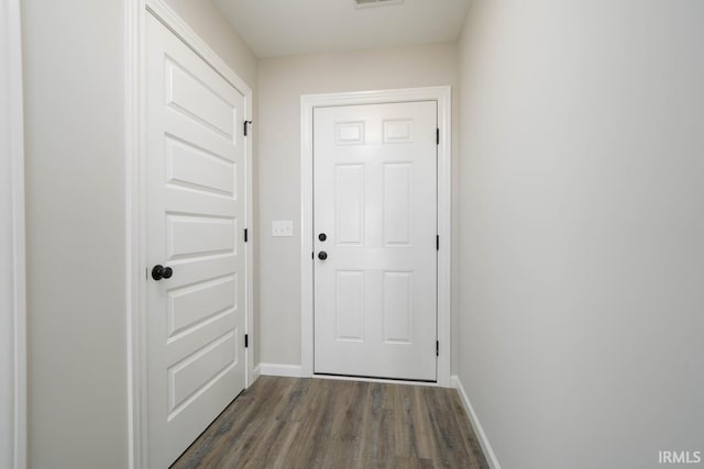 doorway with visible vents, baseboards, and dark wood-style flooring