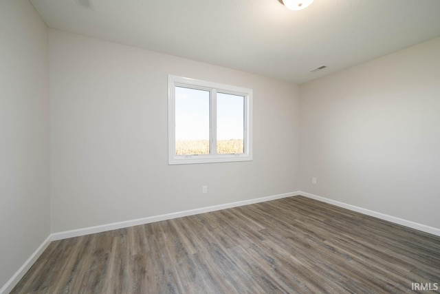 empty room with baseboards and wood finished floors