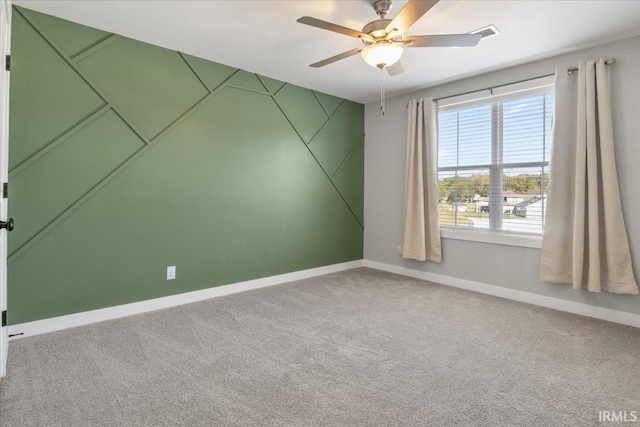 carpeted spare room featuring ceiling fan