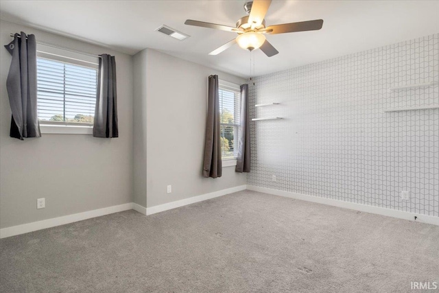 spare room featuring ceiling fan and carpet flooring