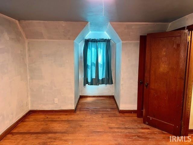 bonus room with hardwood / wood-style floors and vaulted ceiling