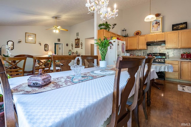 dining space with ceiling fan with notable chandelier, high vaulted ceiling, dark wood-type flooring, and a textured ceiling