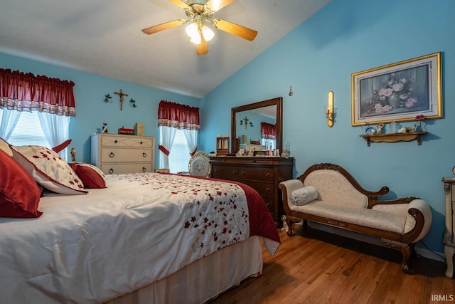 bedroom featuring hardwood / wood-style flooring, multiple windows, ceiling fan, and lofted ceiling