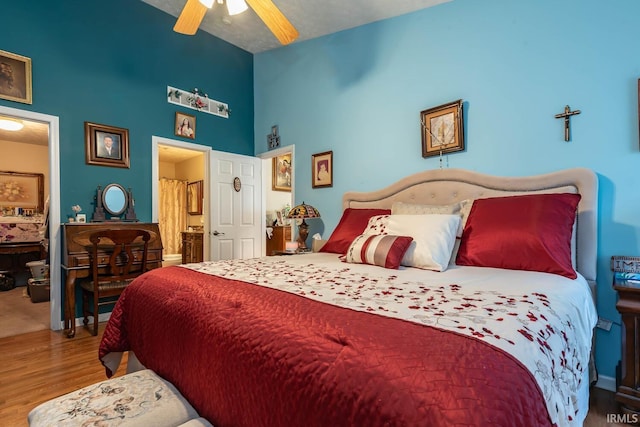 bedroom with ceiling fan, ensuite bath, and wood-type flooring