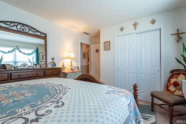 bedroom with a closet, carpet, and a textured ceiling