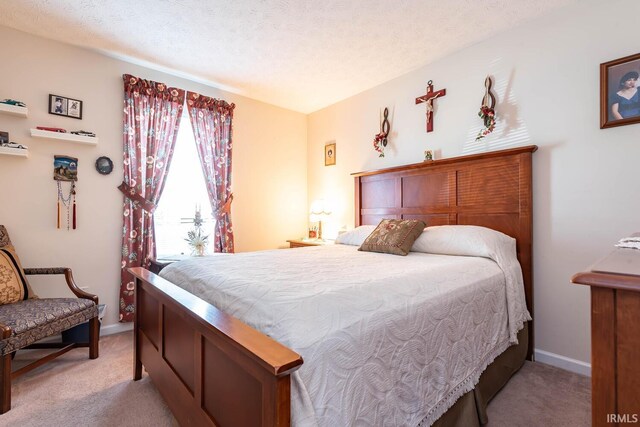 bedroom with a textured ceiling and light carpet