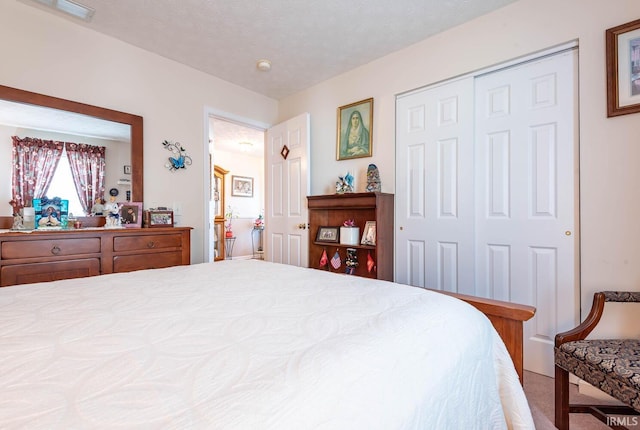 bedroom featuring carpet floors, a textured ceiling, and a closet