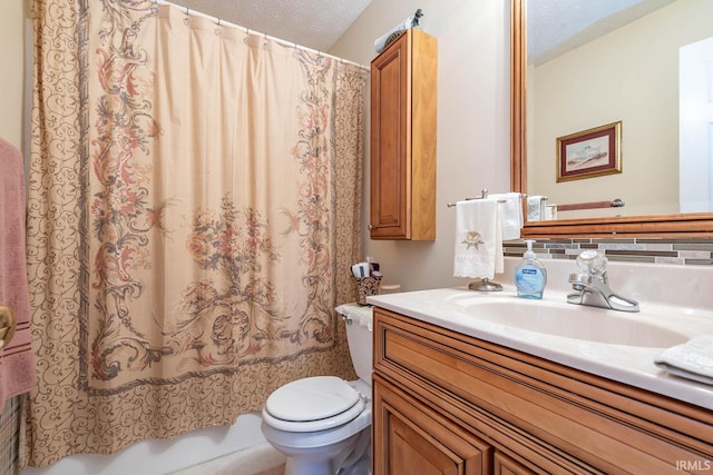 full bathroom featuring a textured ceiling, shower / bath combo with shower curtain, vanity, and toilet