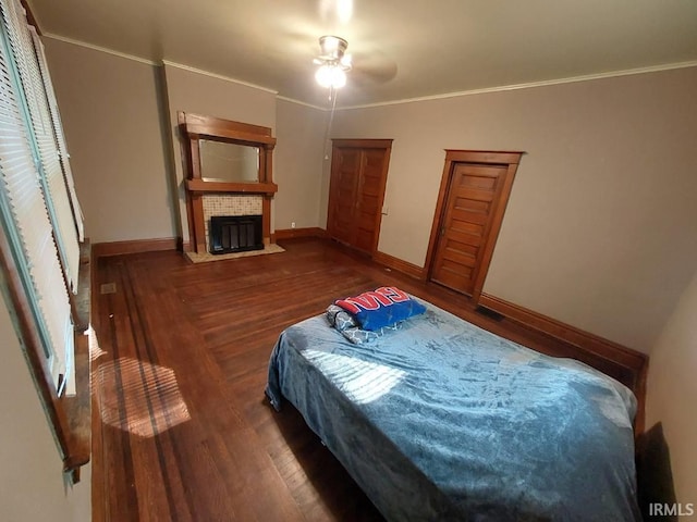 bedroom with crown molding, ceiling fan, and dark hardwood / wood-style flooring