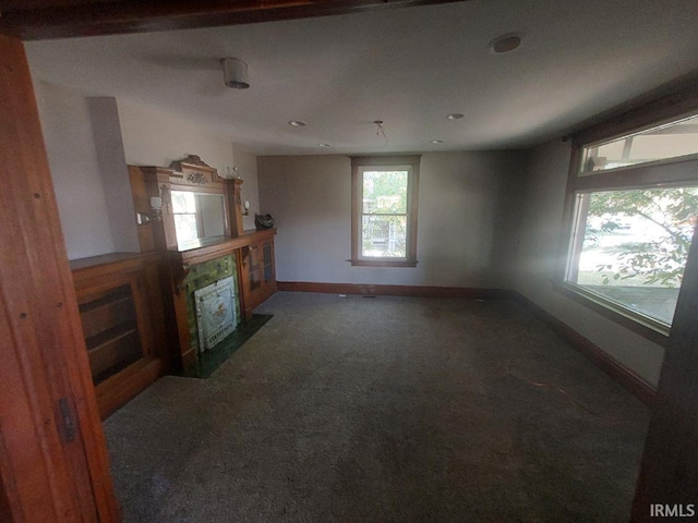 unfurnished living room with dark colored carpet