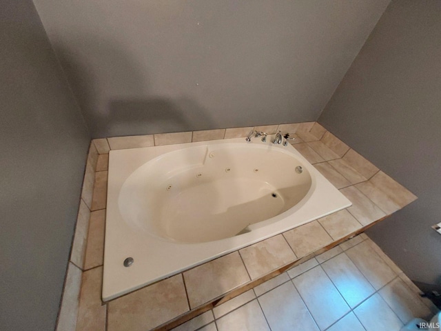 bathroom with tile patterned flooring and tiled tub