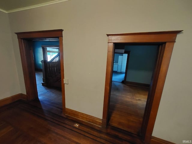 hallway featuring crown molding and dark hardwood / wood-style flooring