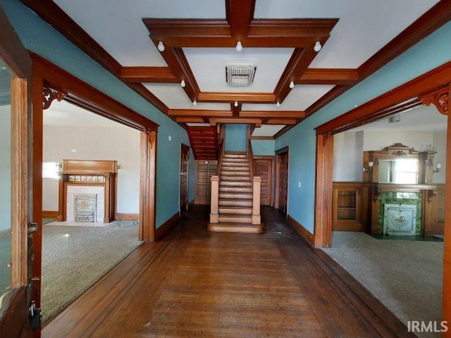 hallway with coffered ceiling, beamed ceiling, crown molding, and dark wood-type flooring