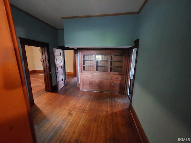 corridor featuring dark wood-type flooring and crown molding